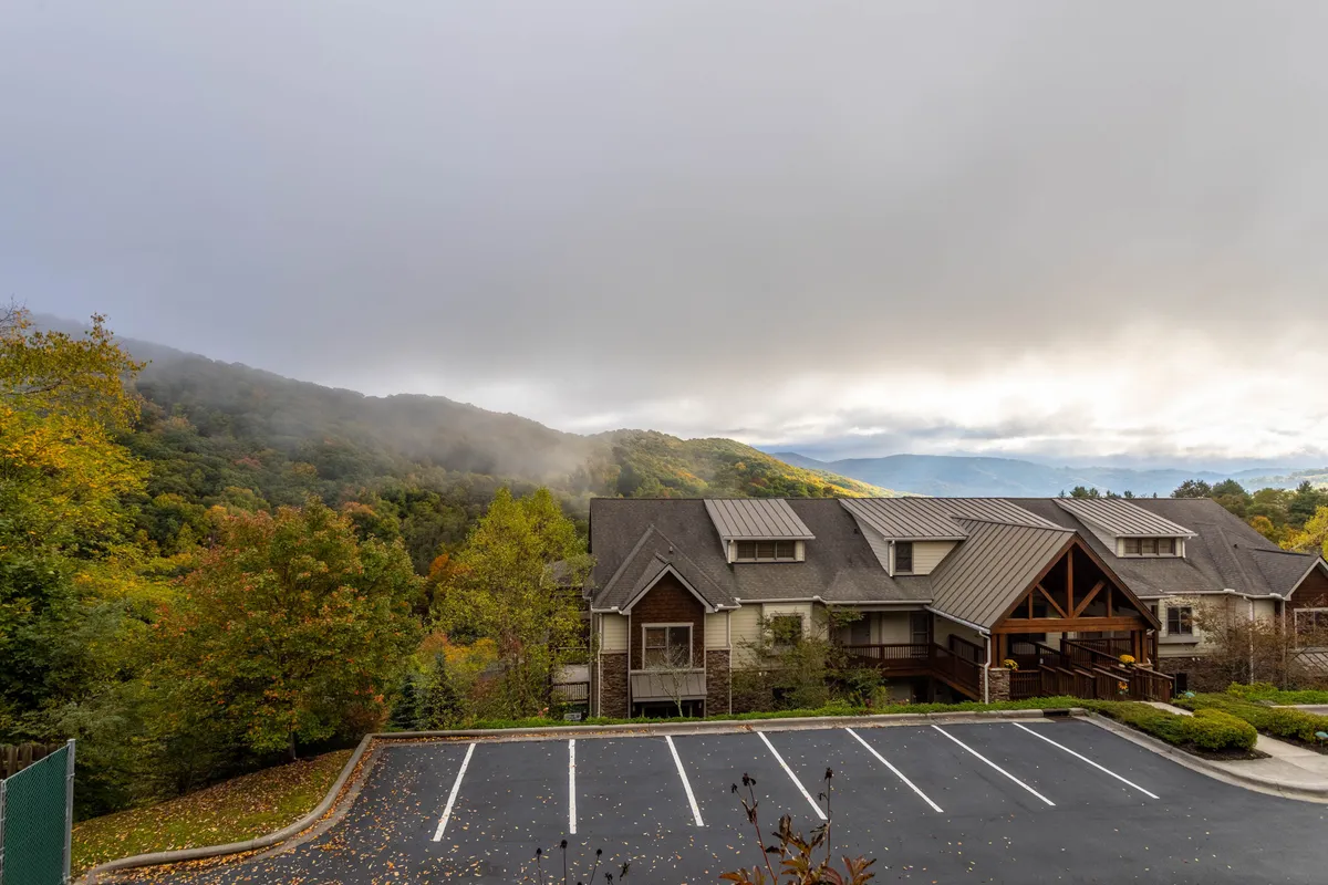 This exterior shot captures Caribou Crossing’s scenic mountain setting, highlighting the building's architecture with a backdrop of expansive mountain views. The peaceful mood and ample outdoor space suggest proximity to nature trails and local attractions, making it ideal for those eager to explore the surrounding area.